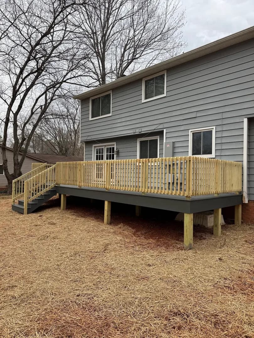 Residential Deck Build by Alex's Lawnscape in Charlotte NC — Pressure-treated wood deck with railing, stairs, and composite decking built off the back of a gray-sided home