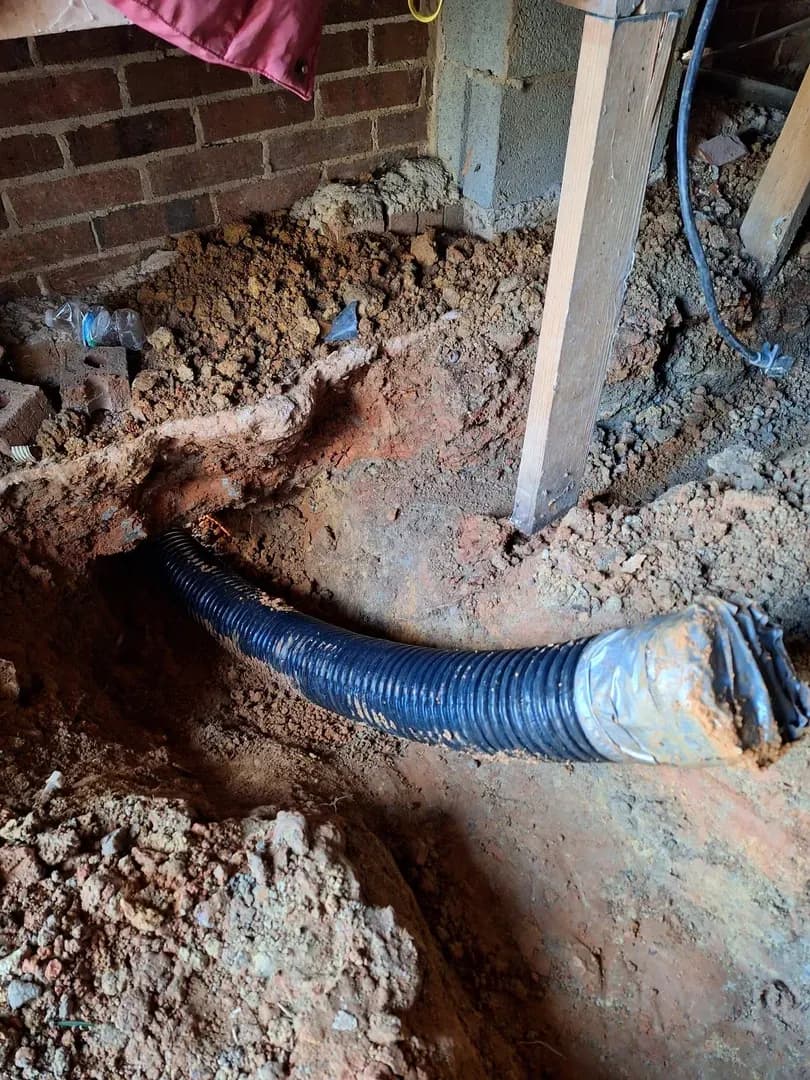 French Drain Pipe Installation by Alex's Lawnscape in Charlotte NC — Corrugated drainage pipe installed at the foundation of a home to manage water runoff
